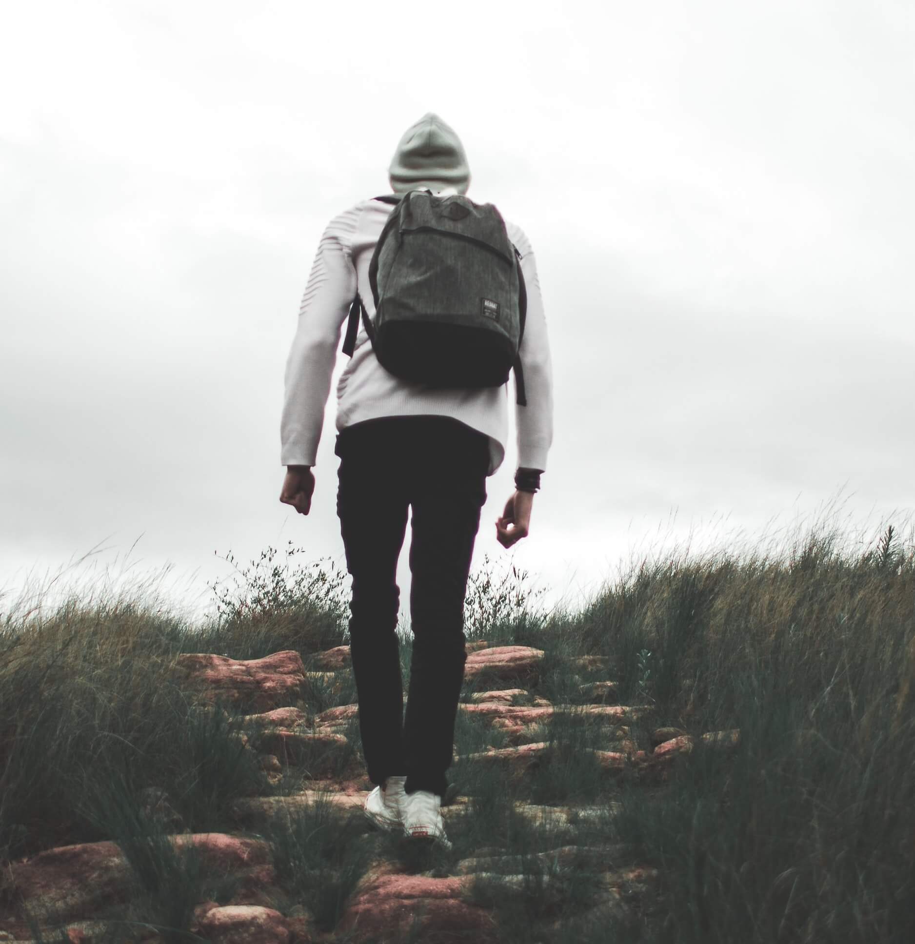 a man walking a hilly path near the summit